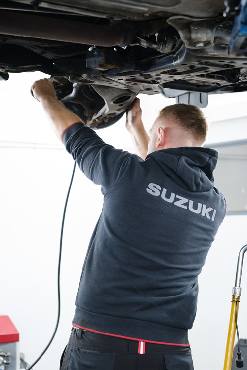 Technicien ajustant une roue sur un pont élévateur